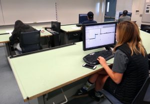 student working in her computer at drawing surface