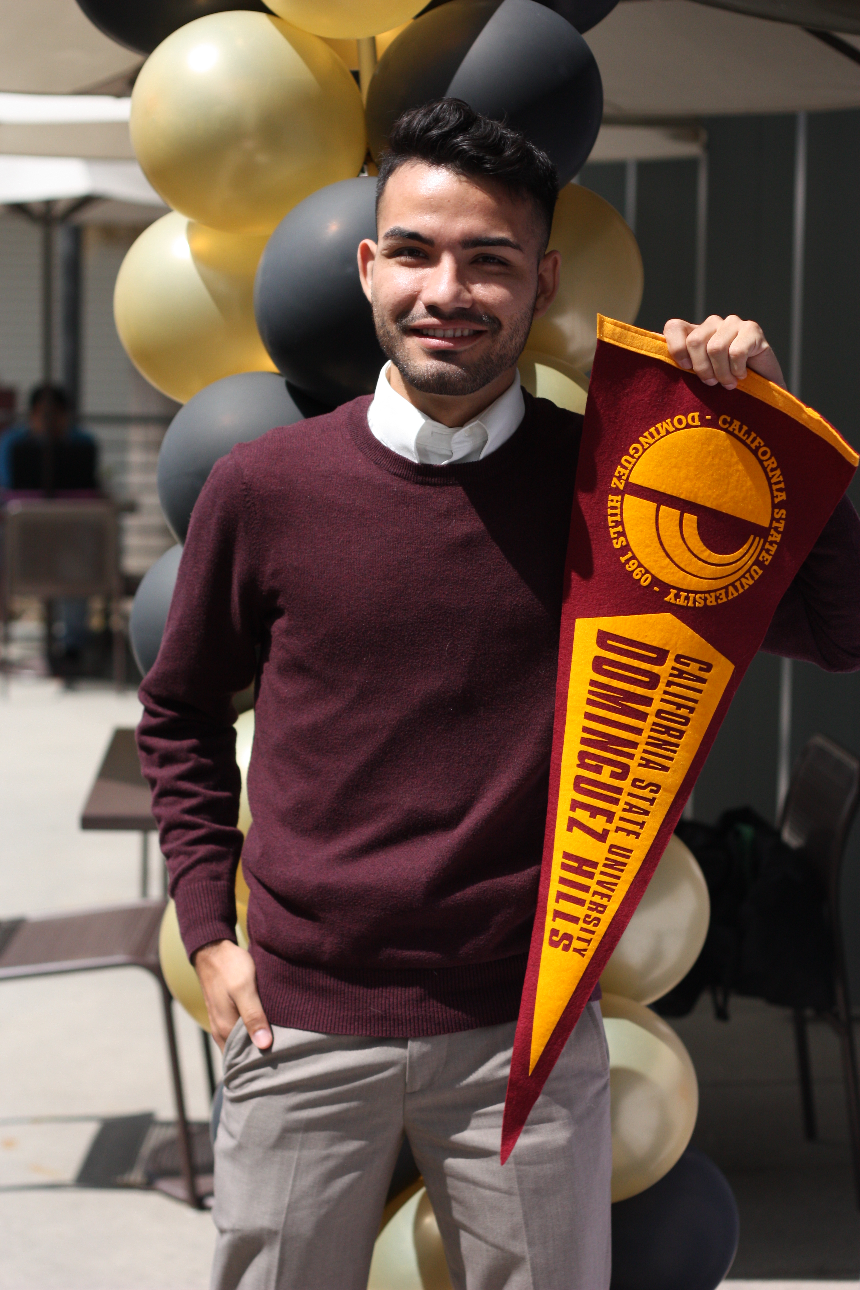 Student holding Cal State Dominguez Hills pennant