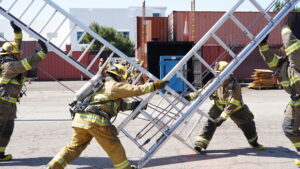 A firemen carrying ladders.