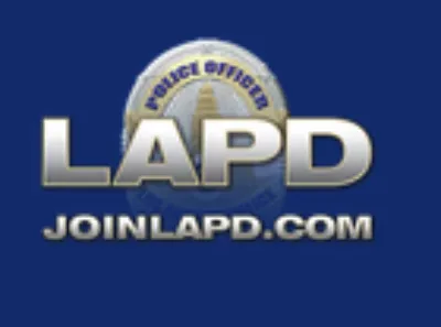 LAPD logo with the words “JOINLAPD.COM” on a blue background. A police badge is faintly visible behind the text.